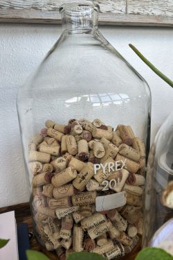 Gathered corks on display in vintage Pyrex jar of favorite bottles of wine as a travel souvenir